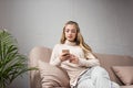relaxed young woman using smartphone on couch Royalty Free Stock Photo