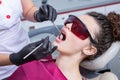 Dentist examining teeth of a young woman patient in a dental clinic. Dentistry concept.