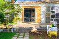 View of the well designed patio area with wooden chairs in the backyard of modern design house. Royalty Free Stock Photo