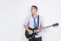 Relaxing asian business man playing electric guitar near the white wall Royalty Free Stock Photo