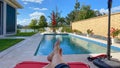 A relaxing backyard swimming pool with red umbrellas