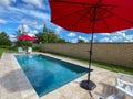 A relaxing backyard swimming pool with red umbrellas