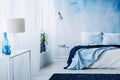 Relaxing bedroom interior with white and blue decorations, double bed and wallpaper Royalty Free Stock Photo