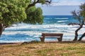 Relaxing bench with sea or ocean view to enjoy calm, peaceful or zen beach with waves washing on shore in remote area Royalty Free Stock Photo