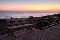 Relaxing bench in a wooden path at the sunset in the beach, peace and relax Royalty Free Stock Photo