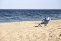 Striped beach chair on a sandy beach.