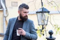 Relaxing coffee break. Hipster hold paper coffee cup and enjoy park environment. Drink it on the go. Man bearded hipster Royalty Free Stock Photo