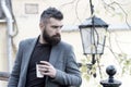 Relaxing coffee break. Hipster hold paper coffee cup and enjoy park environment. Drink it on the go. Man bearded hipster Royalty Free Stock Photo