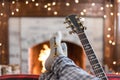 Relaxing with feet up in front of the fire with acoustic guitar