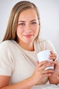 Relaxing with a fresh cuppa joe. Portrait of an attractive young woman relaxing with a cup of coffee. Royalty Free Stock Photo