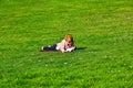 Girl lying on grass and reading