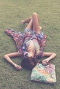 Relaxing in grass. Top view of beautiful young woman in sunglasses and pareo lying on the green grass with beach bag in Royalty Free Stock Photo