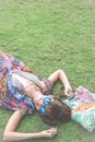 Relaxing in grass. Top view of beautiful young woman in sunglasses and pareo lying on the green grass with beach bag in Royalty Free Stock Photo