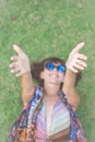 Relaxing in grass. Top view of beautiful young woman in sunglasses and pareo lying on the green grass in the park of Royalty Free Stock Photo