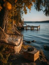 Relaxing in a hammock by a tranquil lakeside at sunset with a vintage camera Royalty Free Stock Photo