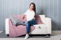 Relaxing at home, comfort. cute young woman smiling, relaxing on white couch, sofa Royalty Free Stock Photo
