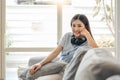 Relaxing at home. Portrait of a young woman smiling on white couch Royalty Free Stock Photo