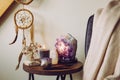 Relaxing home shrine with relaxing objects  amethyst cluster geode lamp illuminated. Royalty Free Stock Photo