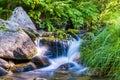 Relaxing landscape of a river with water flowing between the stones and making waterfalls