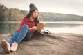 Relaxing moment Asian tourist reading a book on rock Royalty Free Stock Photo