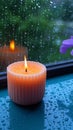 Relaxing moments aroma candles flame glows near a rain drenched window Royalty Free Stock Photo