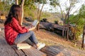 Relaxing moments, Young woman reading a book in nature background. Solo relaxation, color of Hipster Tone.