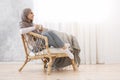 Relaxing Pastime. Calm Arabic Girl Resting At Wicker Chair With Coffee