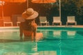 Relaxing by the Pool: Female Vacationer Enjoys Sunny Day