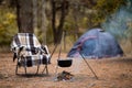 Relaxing and preparing food on campfire in camping, autumn rest in forest