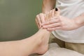 Relaxing professional massage on the female foot in the salon.
