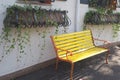 This is a relaxing scene with the the yellow bench by the plants. Royalty Free Stock Photo