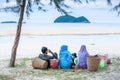 Relaxing by the sea, rear view of Muslim family picnicking under the shady of pine tree