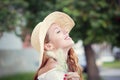 Relaxing and smiling. Young happy woman in a straw hat breathing deeply fresh air outdoor in a park with a green background Royalty Free Stock Photo