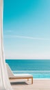 Infinity pool overlooking tranquil ocean with empty sunbed and white curtain on resort terrace Royalty Free Stock Photo