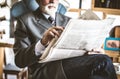 Relaxing time. Senior businessman riding newspaper. Close up image. Royalty Free Stock Photo