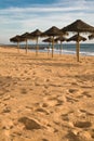 Relaxing under bamboo parasol view on sandy beach in blue sky sunset Royalty Free Stock Photo