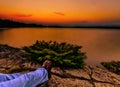 Relaxing Under an Orange Sunset Over a Calm Lake Royalty Free Stock Photo