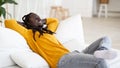 Relaxing Weekend. Happy Smiling Young Black Man Leaning Back On Couch Royalty Free Stock Photo