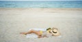 relaxing woman lying and sunbathing at beach, beach accessories and fresh fruit on blanket Royalty Free Stock Photo