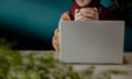 Relaxing and Working via Computer Laptop at Home or Cafe. Smiling Woman holding a Cup of Hot Tea Royalty Free Stock Photo