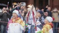 Relay race Sochi Olympic torch in Saint Petersburg. Aged woman pass flame to man. Torchbearers