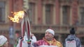 Relay race Sochi Olympic torch in Saint Petersburg. Two torchbearers hold flame. Passing torch