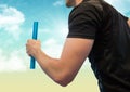 Relay runner mid section against blue and yellow sky Royalty Free Stock Photo