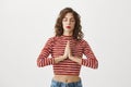 Release body from stress. Portrait of charming european girl holding hands in buddhist gesture or pray, being calm and Royalty Free Stock Photo