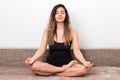 Releasing all bad energy from news. young woman with curly hairs in lotus pose meditating and doing yoga at home Royalty Free Stock Photo