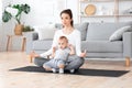 Releasing Stress in Motherhood. Young Mom Meditating At Home With Baby On Laps