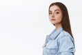 Reliable and determined good-looking confident young sassy woman with long straight hair in denim jacket, standing in Royalty Free Stock Photo