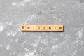 Reliable word written on wood block. Reliable text on cement table for your desing, concept Royalty Free Stock Photo