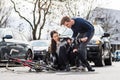 Reliable young man helping an injured woman while waiting for the ambulance