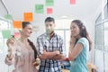 Reliable young workers posting reminders in a modern co-working space